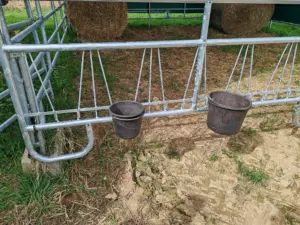 Čelní zábrana vybavená obručemi pro uložení kyblíku s krmivem
